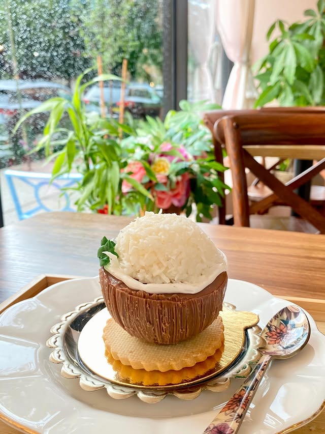 A dessert by the plant-and-flower window at First Cup Cafe